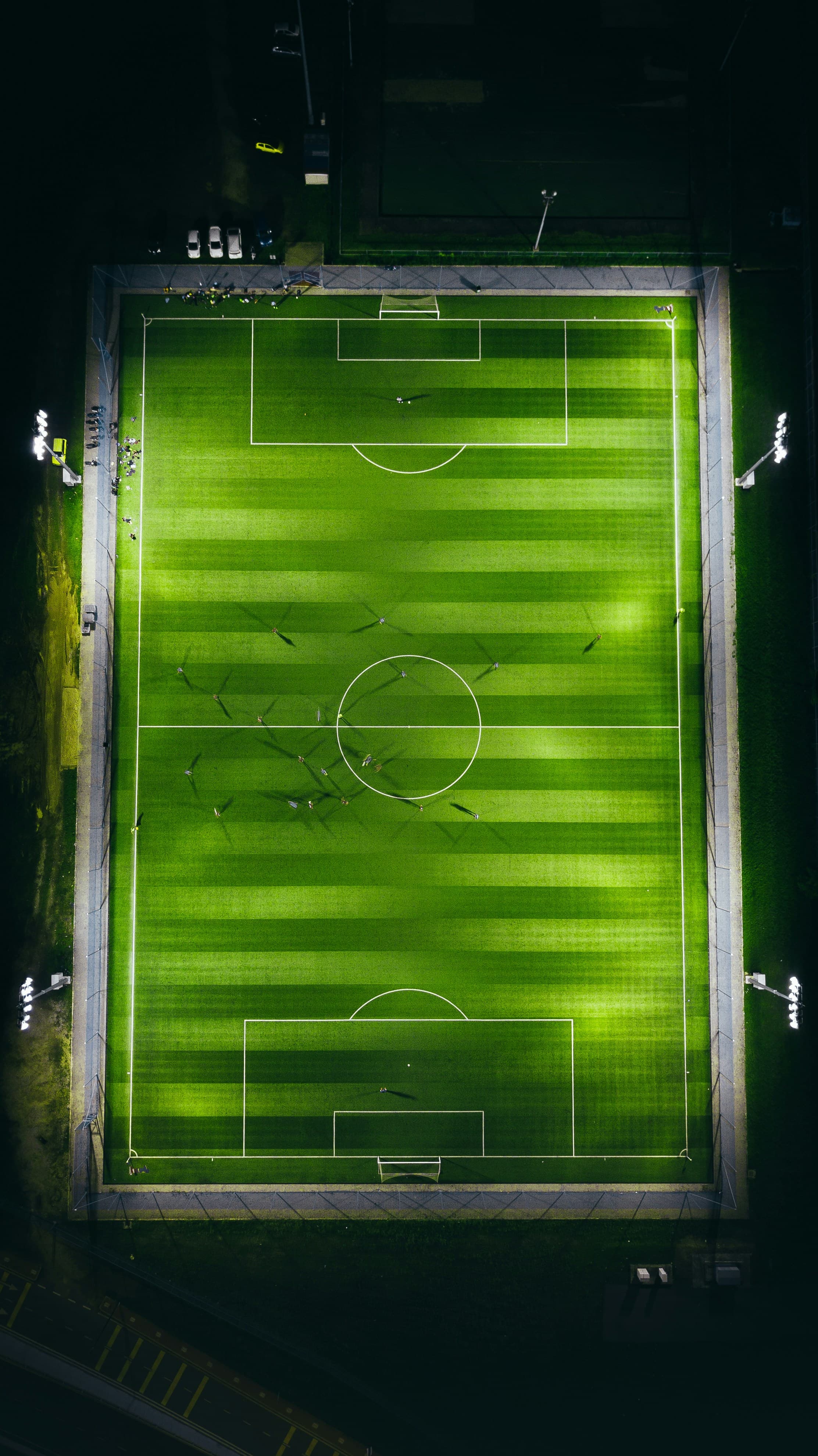 Cancha iluminada durante un entrenamiento nocturno, vista aérea